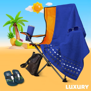 Toalla de algodón egipcio color azul rey de la línea Luxury Zantelo para playa o baño sobre una silla azul.